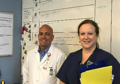 Doctor and nurse stand by white board