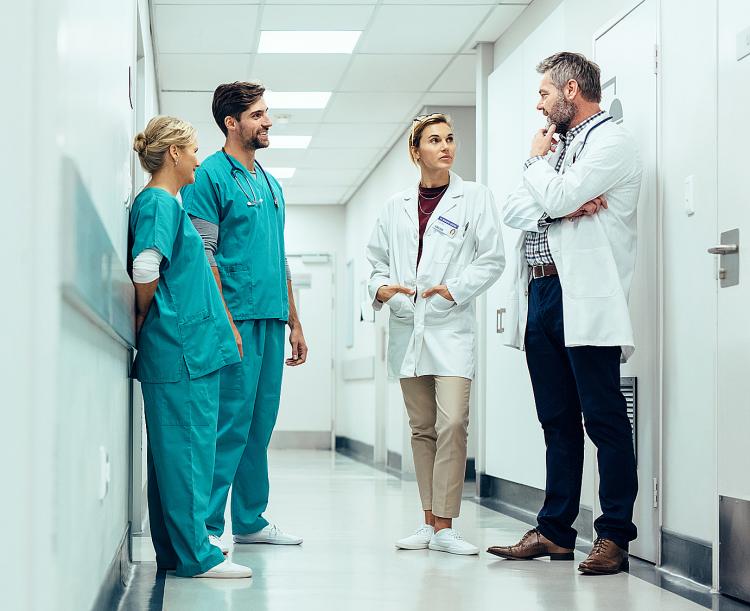 Two doctors and two nurses gather in hospital hallway